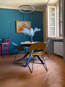 Antica Dimora del Mercato في دومودوسولا: غرفة طعام مع طاولة وكراسي وجدار أزرق