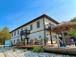 ein großes Gebäude mit einer Terrasse mit Stühlen und einem Sonnenschirm in der Unterkunft Paradise Inn On the Beach in Port Elgin