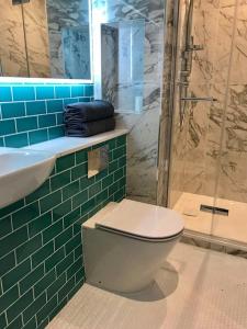 W łazience znajduje się toaleta, umywalka i prysznic. w obiekcie Stylish Notting Hill Air Conditioned studio w Londynie
