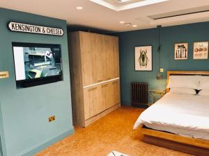 a bedroom with a bed and a flat screen tv at Stylish Notting Hill Air Conditioned studio in London