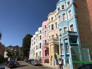 szereg kolorowych domów na ulicy miejskiej w obiekcie Stylish Notting Hill Air Conditioned studio w Londynie