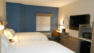 a hotel room with two beds and a flat screen tv at Holiday Inn Express St Augustine Dtwn - Historic, an IHG Hotel in Saint Augustine