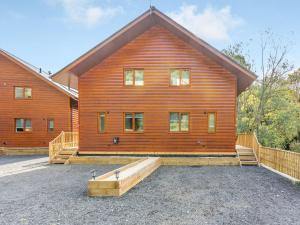 una gran casa de madera con un gran patio delante de ella en Waterside Lodge Six - Uk38264, en Southowram