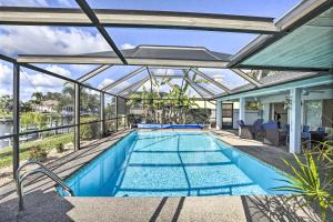 an indoor swimming pool with a glass roof at Cape Coral Home with Gulf and Dock Access in Cape Coral