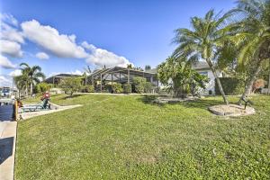 una casa con un patio con palmeras delante en Cape Coral Home with Gulf and Dock Access, en Cabo Coral