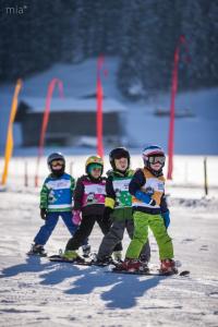 a group of four children on skis in the snow at Schwannerwirt in Weerberg