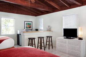 a bedroom with a bed and a bar with stools at Southwinds Motel in Key West