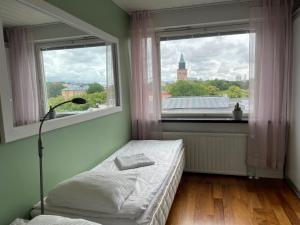 1 dormitorio con cama y ventana grande en Nauti Turun jokirannasta, keskustassa, ylin kerros en Turku