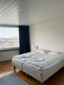 a bedroom with a large bed and a large window at Nauti Turun jokirannasta, keskustassa, ylin kerros in Turku