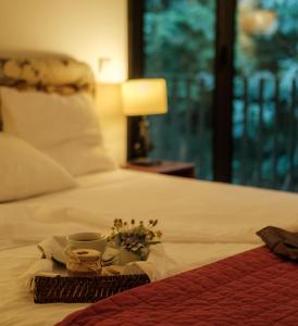 a tray with a coffee cup and flowers on a bed at Braga House & Wine in Braga