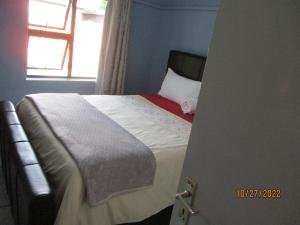 Rúm í herbergi á PS GOOD TIME GUEST HOUSE 53 ALDRED STREET FREEMANVILLE KLERKSDORP
