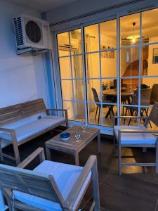 a room with chairs and tables and a balcony at La Grenad'Île in Saint-Pierre