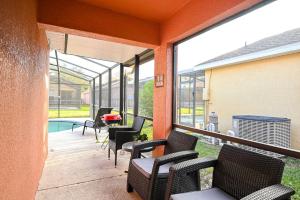 - une terrasse couverte avec des chaises et une piscine dans l'établissement Cozy family vacation with large pool near Disney, à Davenport