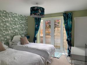 1 dormitorio con 2 camas y puerta corredera de cristal en Mevagissey Holiday Home - sea view and parking, en St Austell
