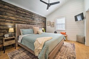 a bedroom with a bed and a wooden wall at A Little Bit of Simple Cabin with Pond Access in Broken Bow