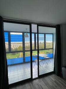 a room with a large window with a table and a view at Studios de standing - Emeraude - Lille euralille in Lille