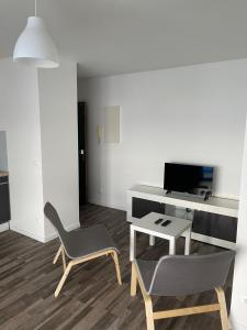 a living room with a desk and a chair and a table at Studios de standing - Emeraude - Lille euralille in Lille