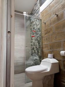 a bathroom with a toilet and a glass shower at Cabañas el Olimpo in Aquitania