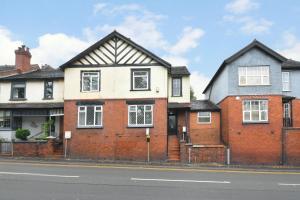a red brick house with a black roof at Beautiful 3-Bed House by MiniStays Stoke-on-Trent in Stoke on Trent