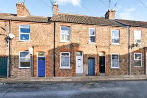 an old brick house with blue doors on a street at Bay tree Cottage in York