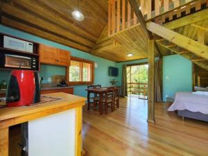 a kitchen and living room with a red appliance on a counter at Chalés Da Cascata - Cereja in Gramado