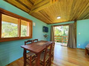 a dining room with a wooden table and chairs at Chalés Da Cascata - Cereja in Gramado