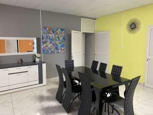 une salle à manger avec une table et des chaises noires dans l'établissement Logement 2 chambres au sud de Mayotte, à Bouéni