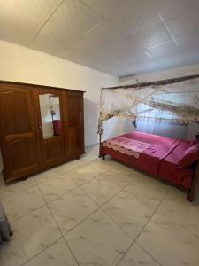 ein Schlafzimmer mit einem Himmelbett in einem Zimmer in der Unterkunft Logement 2 chambres au sud de Mayotte in Bouéni