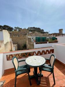 Una mesa y sillas en un balcón con vista. en P&R hostals Maria Rosa, en Tossa de Mar