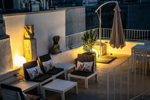 balkon z krzesłami, stołem i parasolem w obiekcie DIMORA PALASCIANO w Alberobello