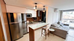 uma cozinha com um frigorífico de aço inoxidável e um sofá em The Expression 112 em Goiânia