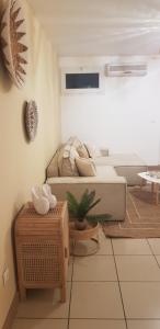 sala de estar con sofá y mesa en PALMAÉ de Boucan Canot T2 St-Gilles A 200M de la plage, en Saint-Gilles-les-Bains