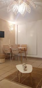 une salle à manger avec une table, des chaises et un lustre dans l'établissement PALMAÉ de Boucan Canot T2 St-Gilles A 200M de la plage, à Saint-Gilles les Bains
