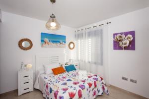 biała sypialnia z łóżkiem i oknem w obiekcie Apartamento Playa Torrox w mieście Torrox Costa