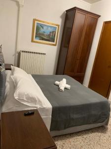 a bed with a white stuffed animal sitting on it at Albergo Abruzzese in Riano