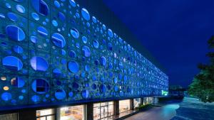 Holiday Inn Express Cangzhou High-Tech Zone, an IHG Hotel في Cangzhou: مبنى يوجد عليه دوائر زرقاء