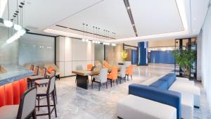 a lobby with chairs and tables and a cafeteria at Holiday Inn Express Cangzhou High-Tech Zone, an IHG Hotel in Cangzhou