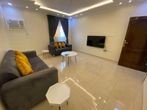 a living room with a couch and a tv at Al Diyafah Apts in Al Madinah