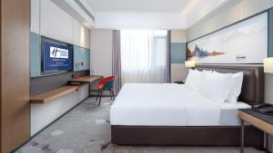 een hotelkamer met een bed en een televisie bij Holiday Inn Express Cangzhou High-Tech Zone, an IHG Hotel in Cangzhou