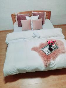 Una cama con una bandeja con flores. en Kuća na dan en Šid