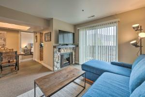 a living room with a blue couch and a fireplace at Park City Condo with View - Walk to ShopsandDining in Park City