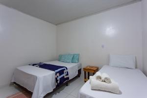 two beds in a room with white walls at POUSADA SALOME in Bonito