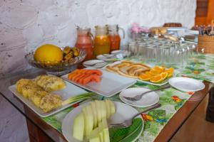 a table topped with plates of food and fruit at POUSADA SALOME in Bonito