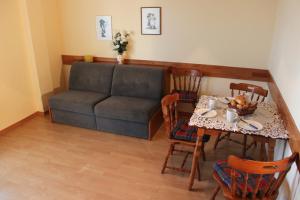 ein Wohnzimmer mit einem Tisch und einem Sofa in der Unterkunft Appartementhaus Waba in Podersdorf am See