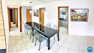 a dining room with a black table and chairs at Vacanze - Terramare in Maceió