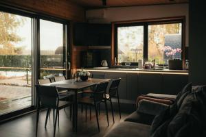 a kitchen and dining room with a table and chairs at Akmeni Nature Resort in Tome