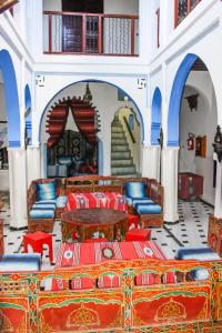 ein Zimmer mit Stühlen, Tischen und einer Treppe in der Unterkunft Cordoba Pension in Chefchaouen