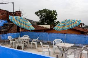 eine Gruppe von Tischen und Stühlen mit Sonnenschirmen darüber in der Unterkunft Cordoba Pension in Chefchaouen