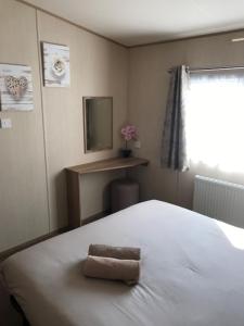 Un dormitorio con una cama blanca con una toalla. en Summer Breeze, en Aviemore