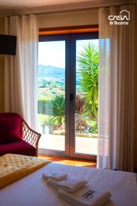 ein Hotelzimmer mit einem Bett und einem großen Fenster in der Unterkunft Casa de Naceiros - Ponte de Lima in Viana do Castelo + 105 Fotos